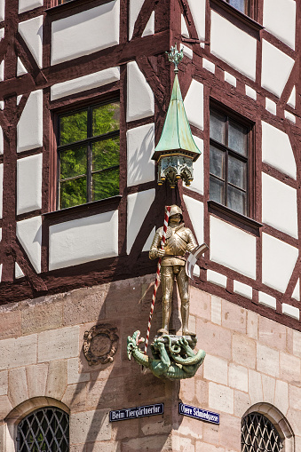 Nuremberg, Germany - July 30, 2022: St. George statue on the Durer house, fachwerk style