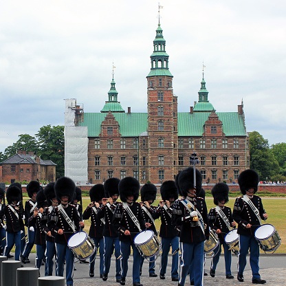 Copenhagen, Denmark - July 1, 2022: Royal guardsmen marching in field dress in Rosenborg slot. Rosenborg is famous castle and museum of Copenhagen.