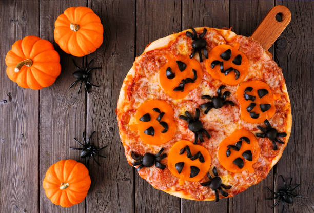 istock Halloween jack o lantern pizza table scene on a dark wood background 1418503145
