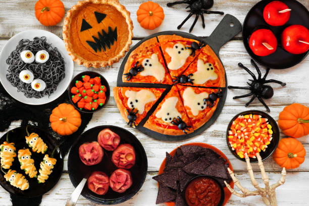 istock Fun Halloween dinner party table scene over a white wood background 1418503314