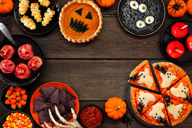 istock Fun Halloween dinner party frame over a dark wood background 1418503441
