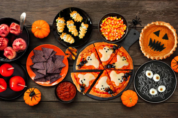 istock Fun Halloween dinner party table scene over a dark wood background 1418503449
