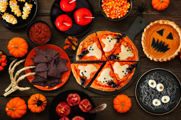 istock Fun Halloween dinner party table scene over a dark wood background 1418503490