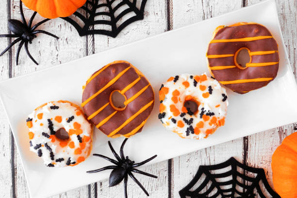 istock Halloween donuts above view table scene on white wood 1418503640