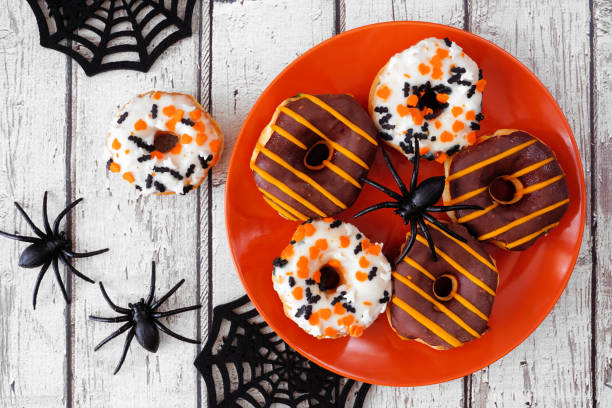 istock Halloween donuts table scene on a white wood background 1418503716