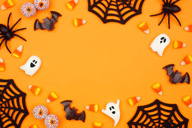 istock Halloween frame of scattered candy and decor over an orange background 1418504136