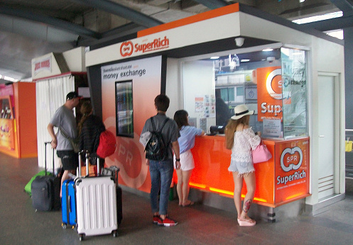 People Standing With Travelling Bag, Changing Their Foreign Currency To Thai Baht Scene In Bangkok Thailand Southeast Asia