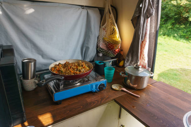 Typical Vanlife situation during cooking dinner with pan on a gas stove stock photo