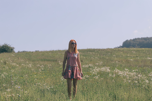 Adult female on green grass meadow with wild flowers