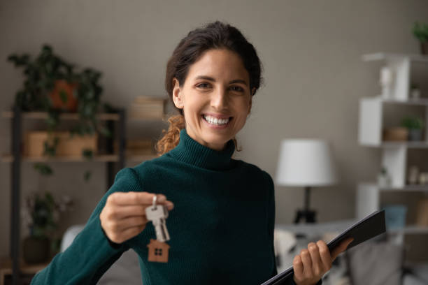 Happy young female real estate agent proposing apartment to client. stock photo