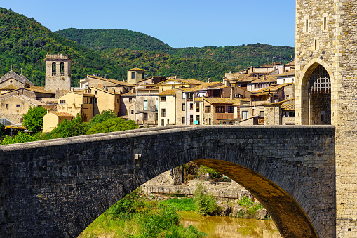 Old stone bridge and medieval houses in the background in the tourist city of Besalu, Girona, Spain