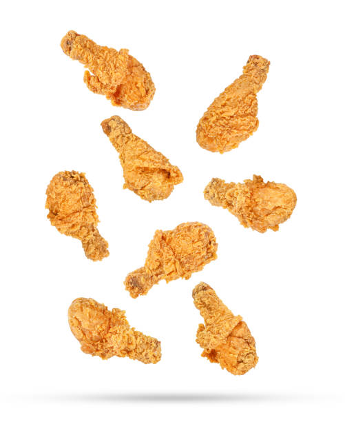 istock Fried chicken legs falling in the air isolated on white 1418509660