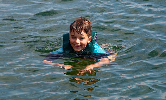 Young boy swims in Lake Okanagan