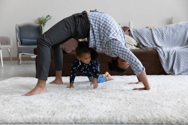 istock Active yogi dad hold bridge stand on white soft carpet 1418516850