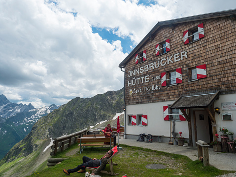 Stubai Valley, Innsbruck-Land, Tirol, Austria, July 6, 2020: hiker people resting at terrace of Innsbrucker Hutte, an alpine mountian hut at summer day.