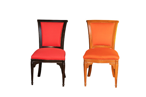 Two isolated old wooden chairs with colored seats
