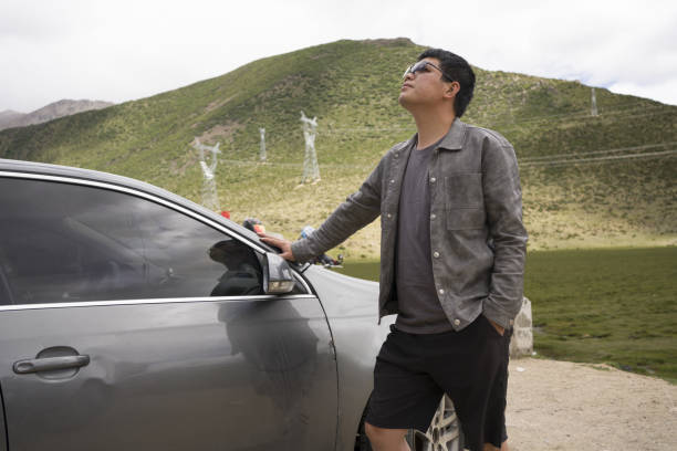 Asian men look at the scenery outside the car