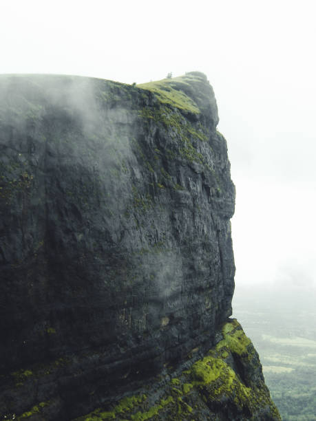 A Mountain Peak in Naneghat, Maharashtra, India. There's some fog and clouds also covering up some part of the Peak as the shot was taken in Rainy season in Western Sahyadri Ghats Of India