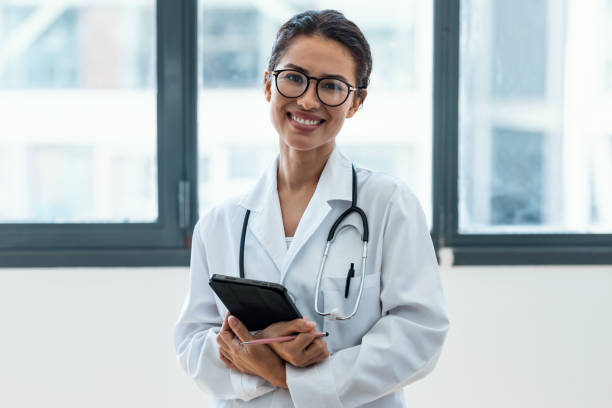istock Female doctor using her digital tablet while standing in the consultation. 1418526725