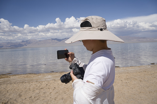 Asian men taking pictures by the lake