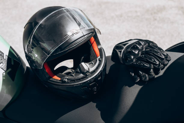 istock Black protective gloves for a motobiker with plastic inserts and a black helmet 1418529662