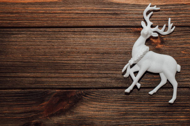 istock Artificial toy deer Christmas decoration on wooden table background 1418530261