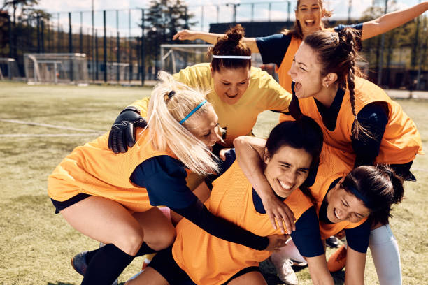 istock Women's soccer team celebrating victory at stadium. 1418532127