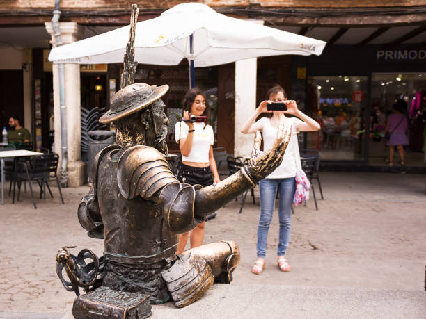 Detail of the statue of Don Quixote in the foreground and tourists photographing it in the background. Alcalá de Henares, Spain - 18 June 2022: Detail of the statue of Don Quixote in the foreground and tourists photographing it in the background. alcala de henares stock pictures, royalty-free photos & images