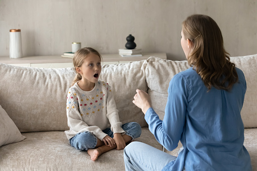 Singing teacher training student girl kid at home. Speech therapist teaching child to do voice, speaking exercises, helping to cope stutter, bad pronunciation, communication problems