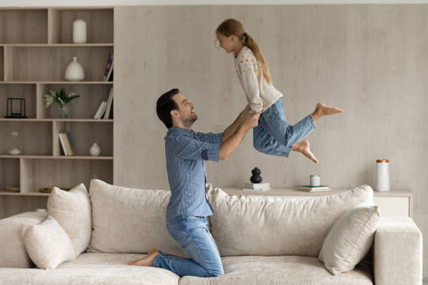 istock Excited happy strong dad lifting cheerful daughter 1418536511