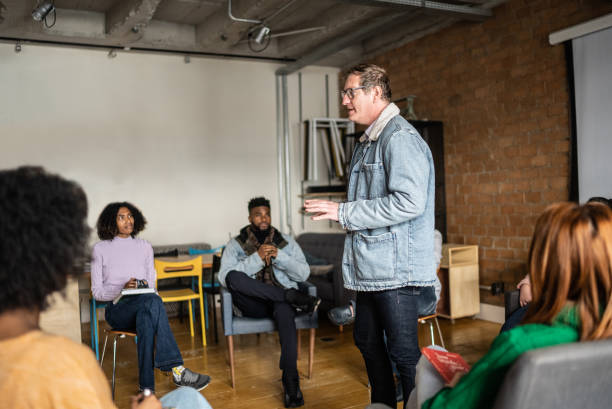 istock Mature man giving a lecture in an university or group therapy 1418536578