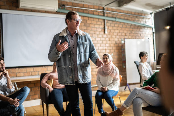 istock Mature man giving a lecture in an university or group therapy 1418536612