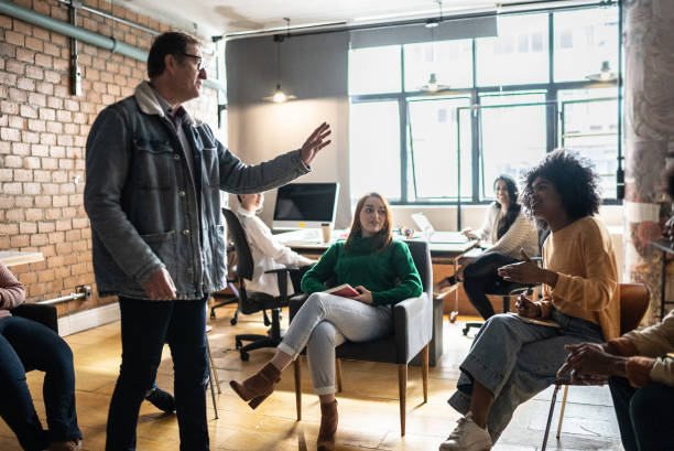 istock Mature man giving a lecture in an university or group therapy 1418536627