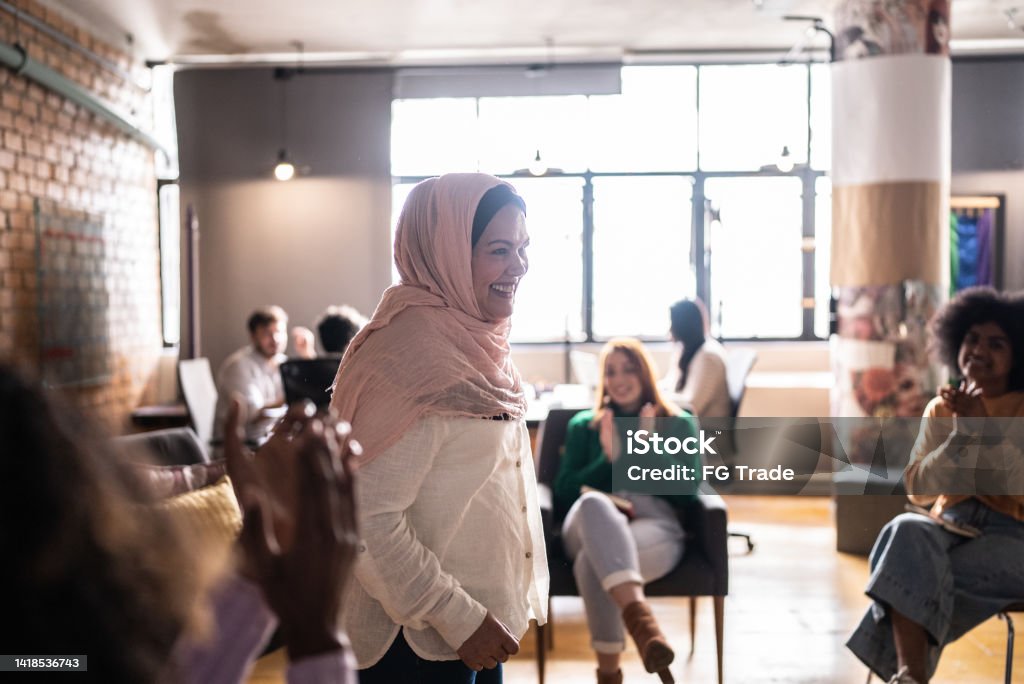 Mature muslim woman giving a lecture in an university or group therapy Group Of People Stock Photo