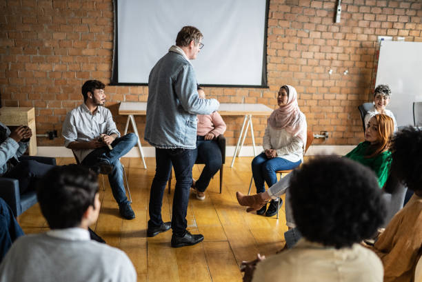 istock Mature man giving a lecture in an university or group therapy 1418536751