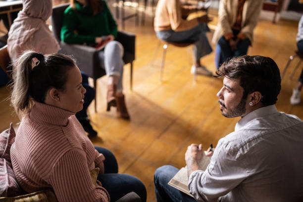 istock Colleagues talking in a seminar or group therapy - including a person with special needs 1418537256