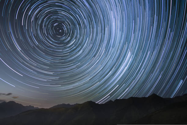 istock silhouetted mountains with circumpolar star trails in northern sky 1418538619