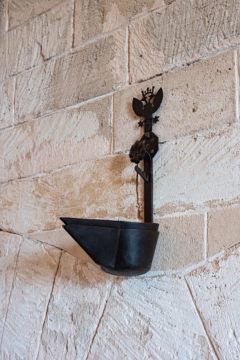 Toma vertical de una antigua lámpara de aceite colgada en la pared del castillo de Bellver, Palma, España photo