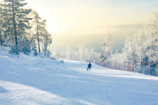 istock ski slope winter landscape, mist sky and forest. skier goes down, rear view 1418541723
