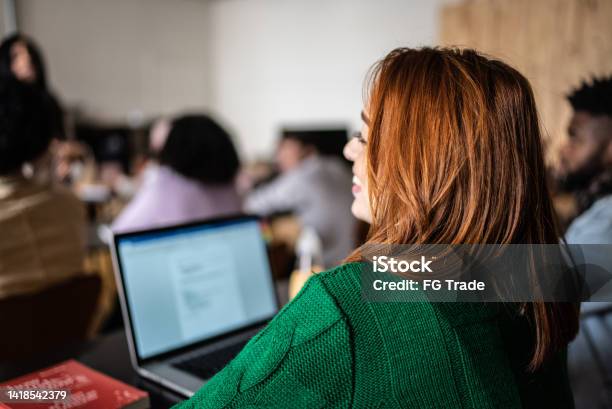 Students During Class In The University Stock Photo - Download Image Now - Lecture Hall, Candid, Redhead