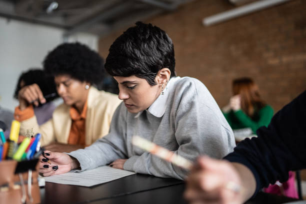 istock Young woman doing a test during class in the university 1418543180