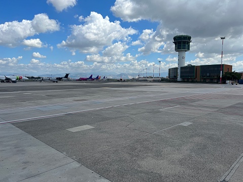 Stationary aeroplanes and control tower on Milan airport runway