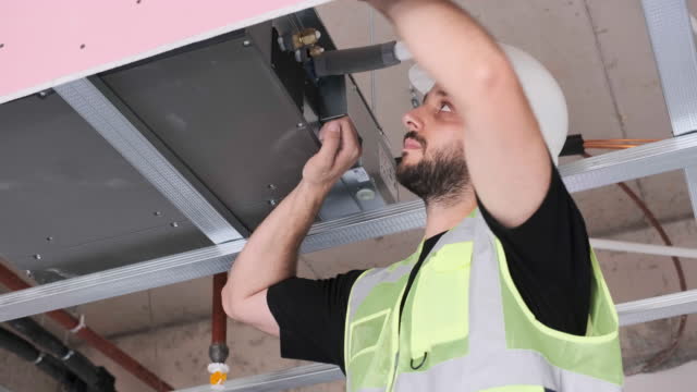 handsome young worker installing air conditioner