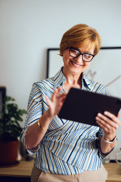 istock Smiling Senior Woman Using Digital Tablet At Home 1418544713
