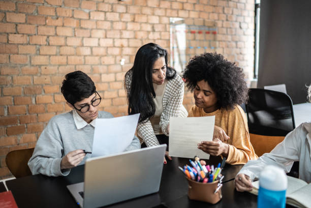 istock Teacher helping students during class in the university 1418544886