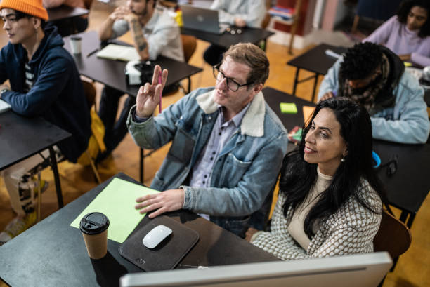 istock Mature man with hands raised during class in the university 1418548386