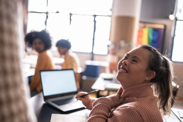 Young woman with special needs talking to teacher in the classroom Young woman with special needs talking to teacher in the classroom special education stock pictures, royalty-free photos & images