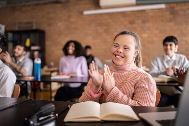 Young woman with special needs clapping in the classroom Young woman with special needs clapping in the classroom community college stock pictures, royalty-free photos & images