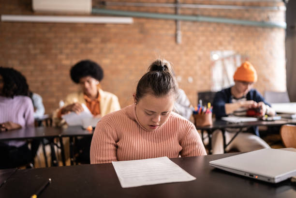 istock Young woman with special needs doing a test in the classroom 1418549268