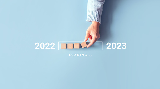 Cargando nuevo año 2022 a 2023 con cubo de madera a mano en barra de progreso. Comience el nuevo año 2023 con el plan de metas, el concepto de meta, la estrategia. photo